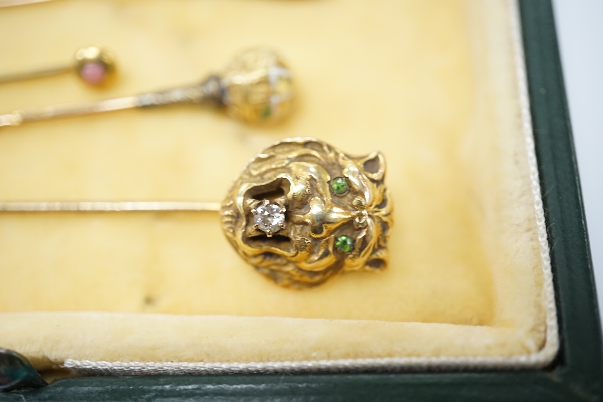 A collection of six assorted mainly early 20th century stick pins including tiger's head set with diamond and green garnets, 68mm. Condition - poor to fair